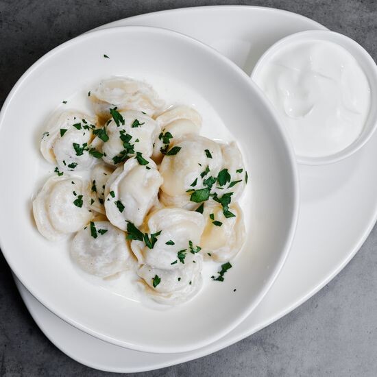 Пельмени с соусом бешамель и сметаной