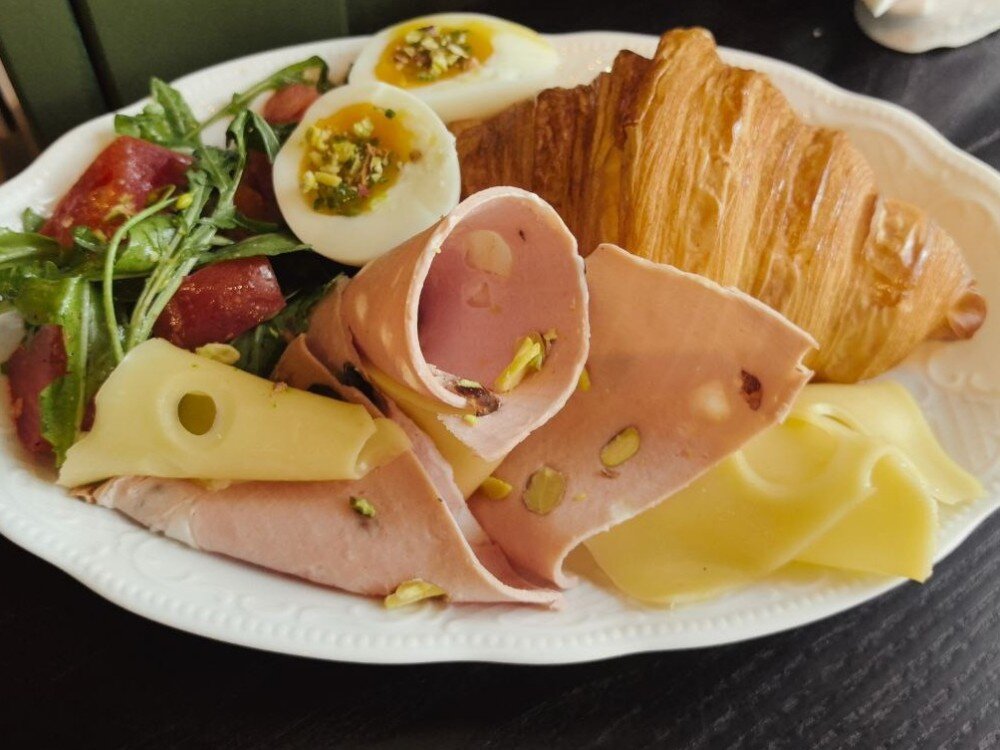 Круассан с мортаделлой, рукколой, томатом и фисташкой