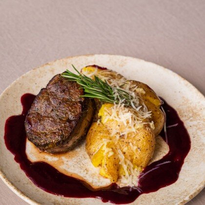 Стейк из говядины с печёным картофелем и соусом из черной смородины